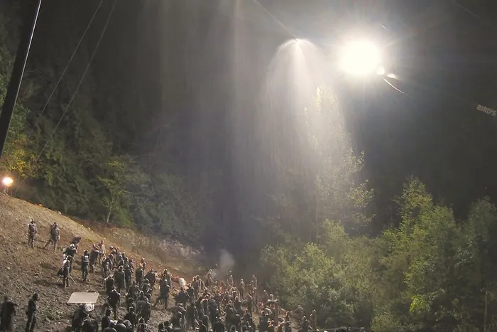 Industrial cranes for rain and lighting above the night battlefield.